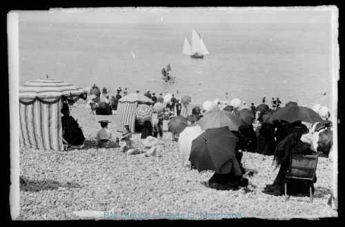 Foule sur les galets avec parasols et barques (vue de la)