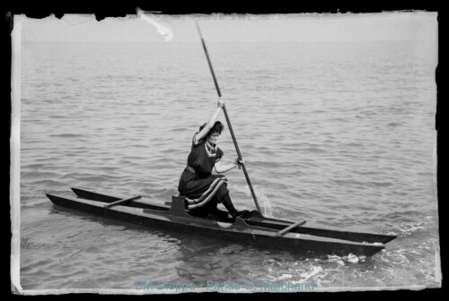 Femme sur une espèce de canoë catamaran à rame (vue d'une)